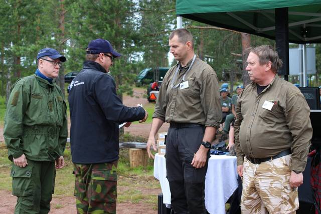 RUL palkitsi Virolahden ja Miehikkälän Reserviuopseerikerhon vuoden 2013 maanpuolustusteko-tunnustuksella. Liiton edustajat, toiminnajohtaja Janne Kosonen (vas) ja puheenjohtaja Mikko Halkilahti luovuttivat asiaakoskevan kunniakirjan puheenjohtaja Petri Rajajärvelle ja varapuheenjohtaja Erkki Rikkolalle Salpavaelluksen päätösjuhlassa 2014. Kuva Salpavaellus 2014 Emilia Ristola.